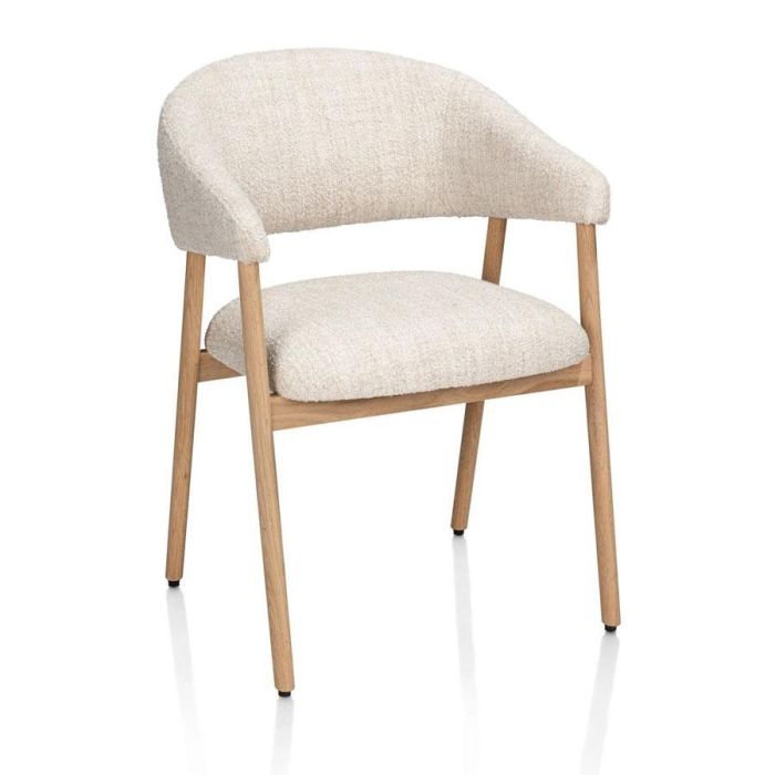 Armstoel Kira van XOOON in crème Luton-stof met armleuningen en massief eikenhouten onderstel in natural, schuin van voren gefotografeerd.