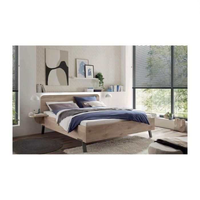 Wiemann ledikant Delft in moderne slaapkamer met groot raam, wit beddengoed en blauwe sprei.