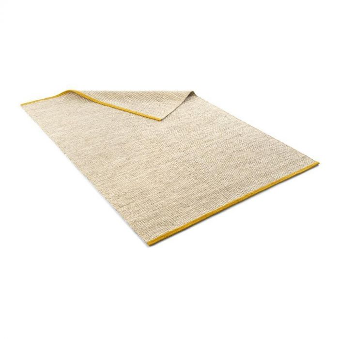 Karpet Rye van Pode handgemaakt van natuurlijke materialen. Getoond is de beige variant met goudkleurige uiteinden.