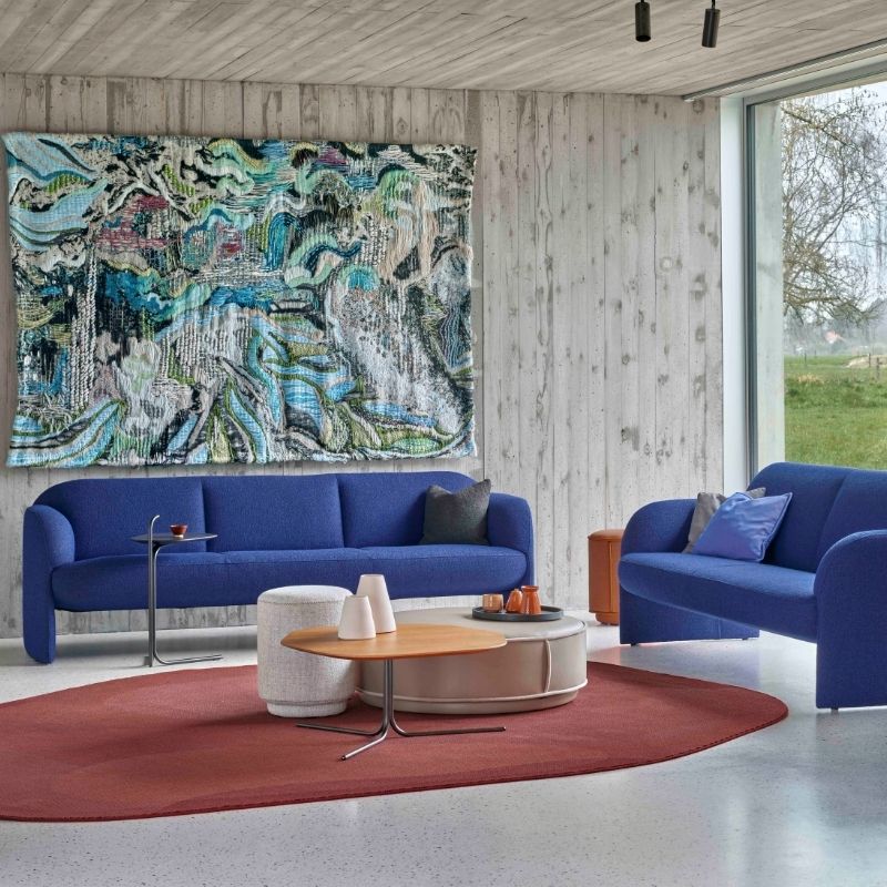 Woonkamer van Leolux met blauwe modiusbank, een kleed en bijzettafels