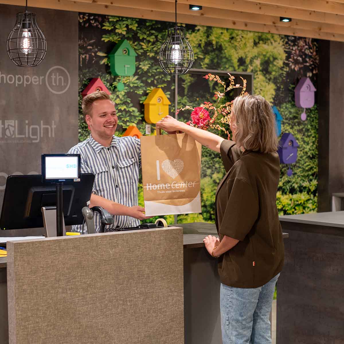 Een papieren tas met het logo van Home Center erop