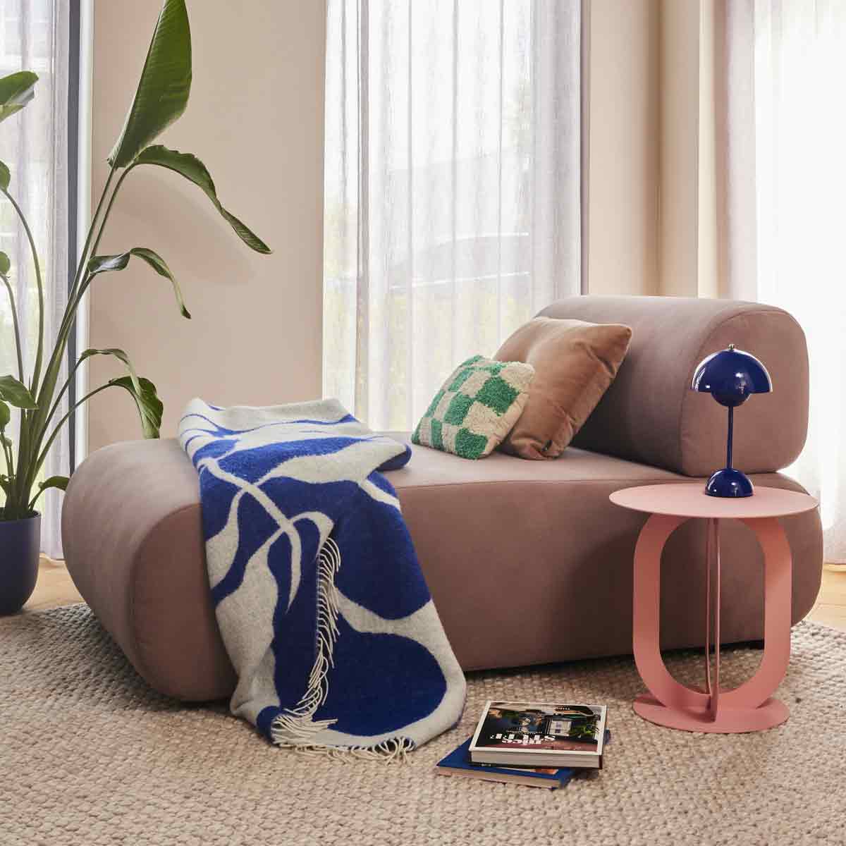 Zitbank met oudroze kleur met blauw kleed en roze bijzettafel van Noga