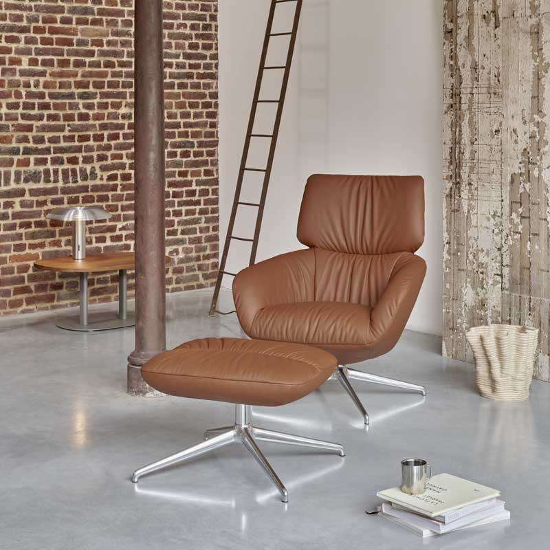 Leolux design fauteuil met hocker in bruin leer, moderne setting met industriële en rustieke details