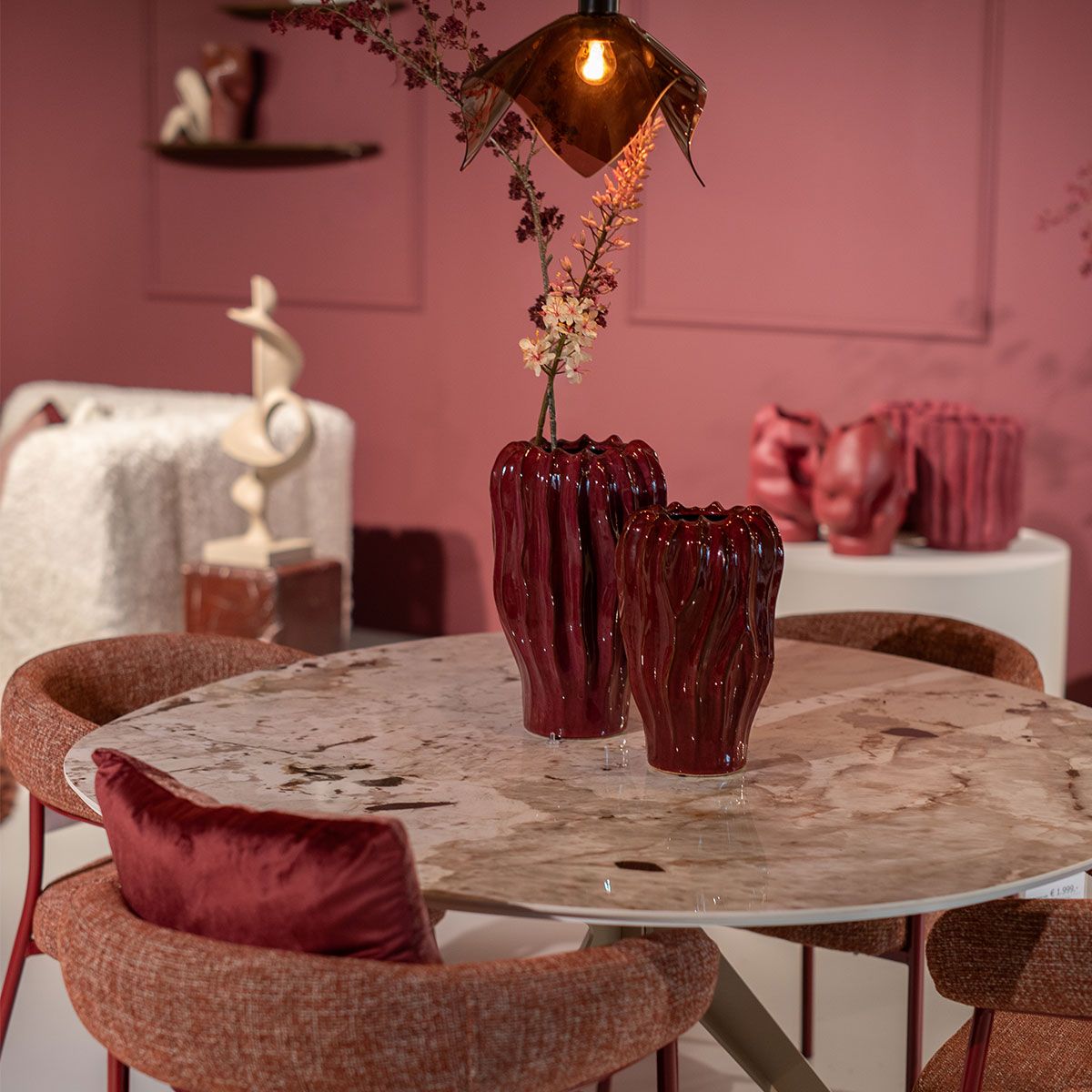 Comfortabele bruine fauteuil met ronde vormen op beige vloerkleed naast open wandkast