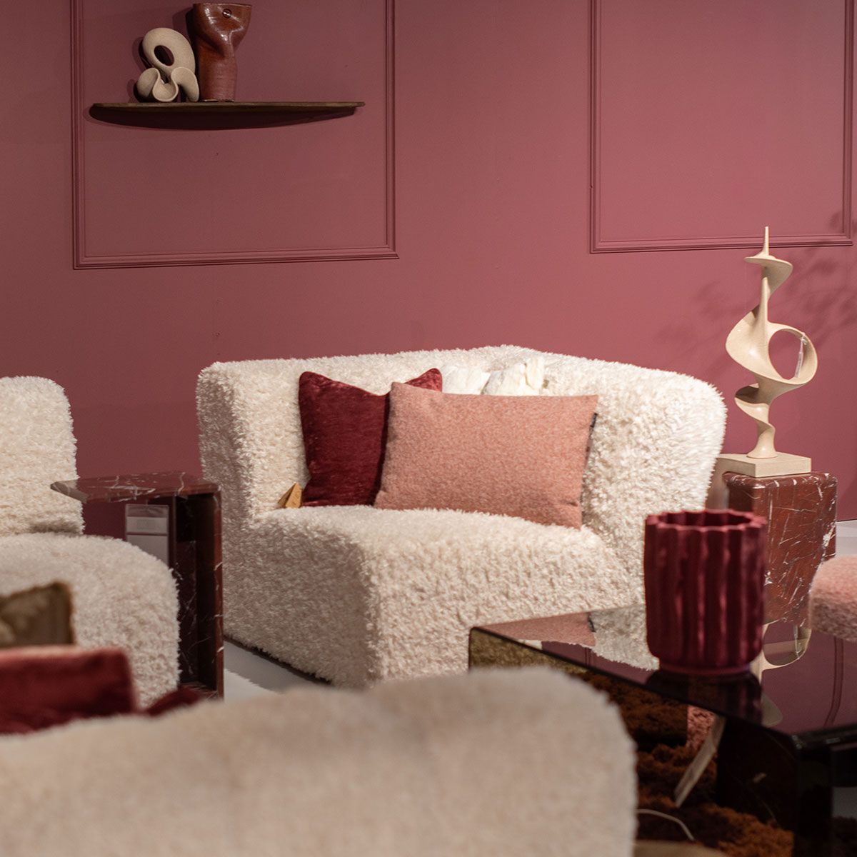 Collage van interieurstijlen met marmer, donkerrode tinten, beige bank en ronde vloerkleed