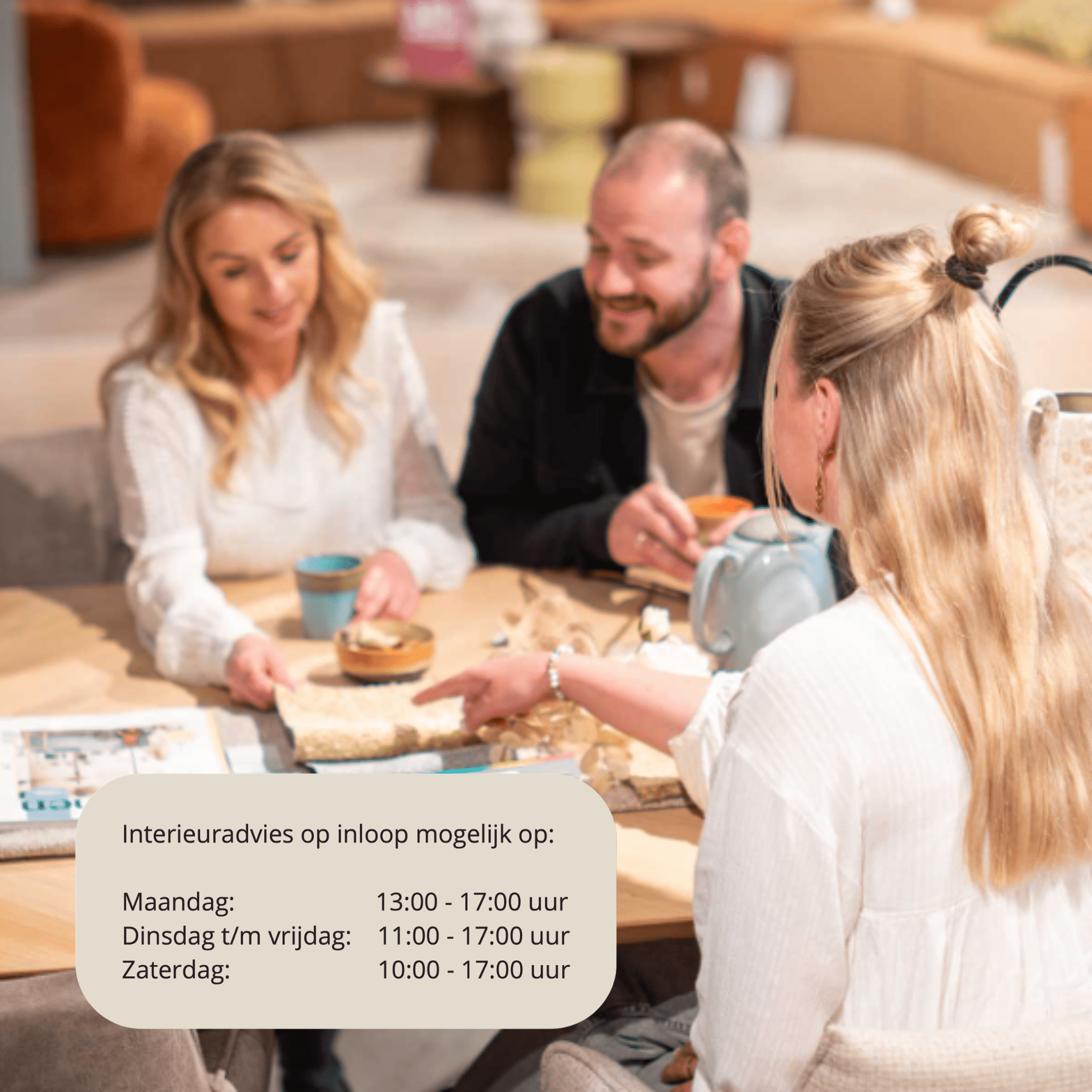 Een interieurstylist van Home Center wijst naar stofstalen tijdens een gratis interieuradvies gesprek met een koppel aan tafel, voorzien van een kleurenwaaier, vtwonen magazine en koffie