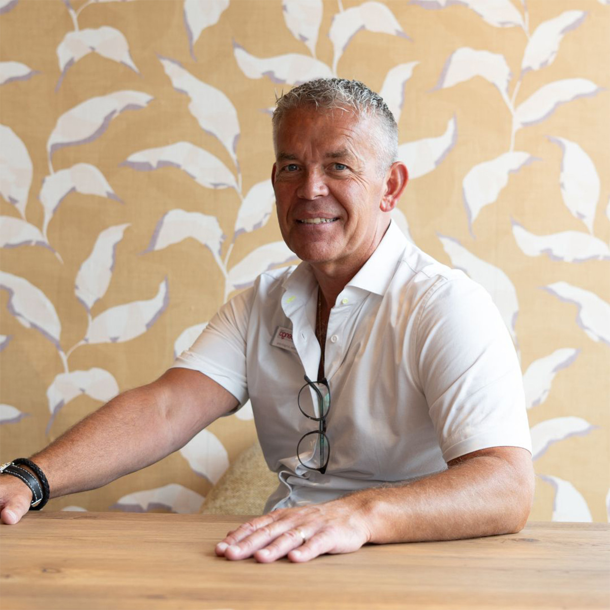 foto van een man aan een eettafel met kleurrijk behang