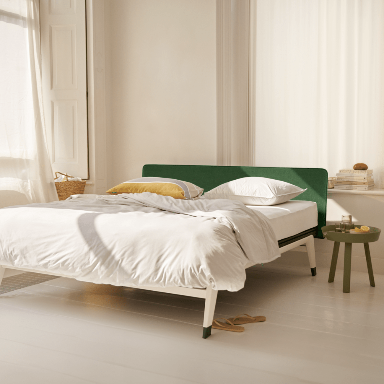 Lichte slaapkamer met modern bed en groene accenten