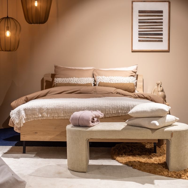 Sfeervol opgemaakt bed bij Home Center met neutrale bruine en beige tinten
