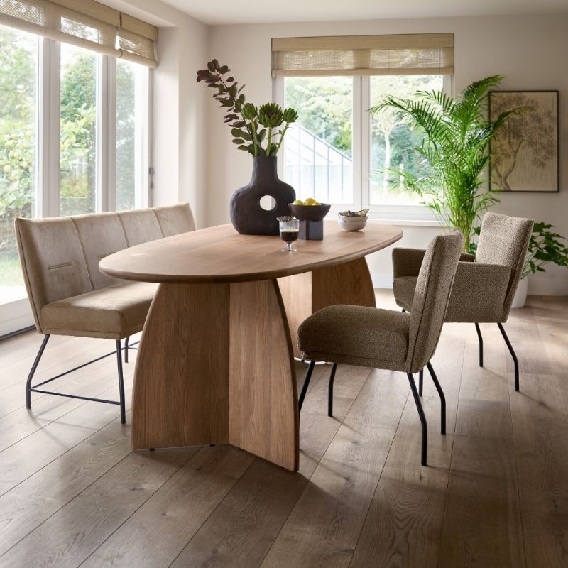 Eethoek van INHOUSE met een houten eettafel, een zitbank en twee stoelen met bruine tinten