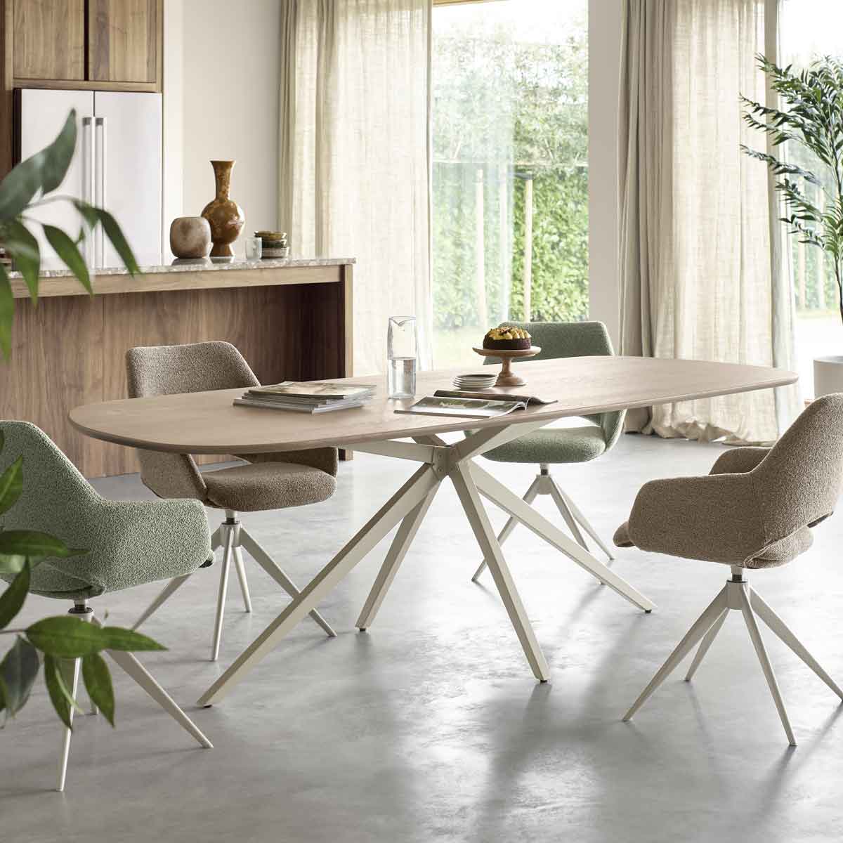 Eethoek met rustige tinten, een houten tafel en vier eettafelstoelen en een keuken op de achtergrond