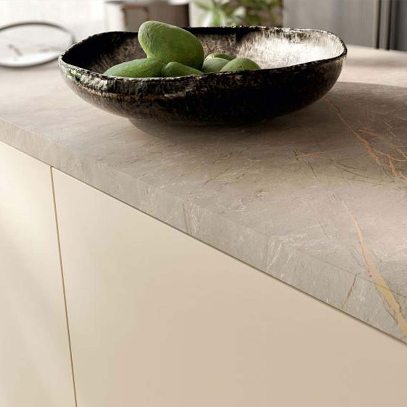 Close-up van beige keukenkast met grijs marmeren werkblad en zwarte schaal met fruit