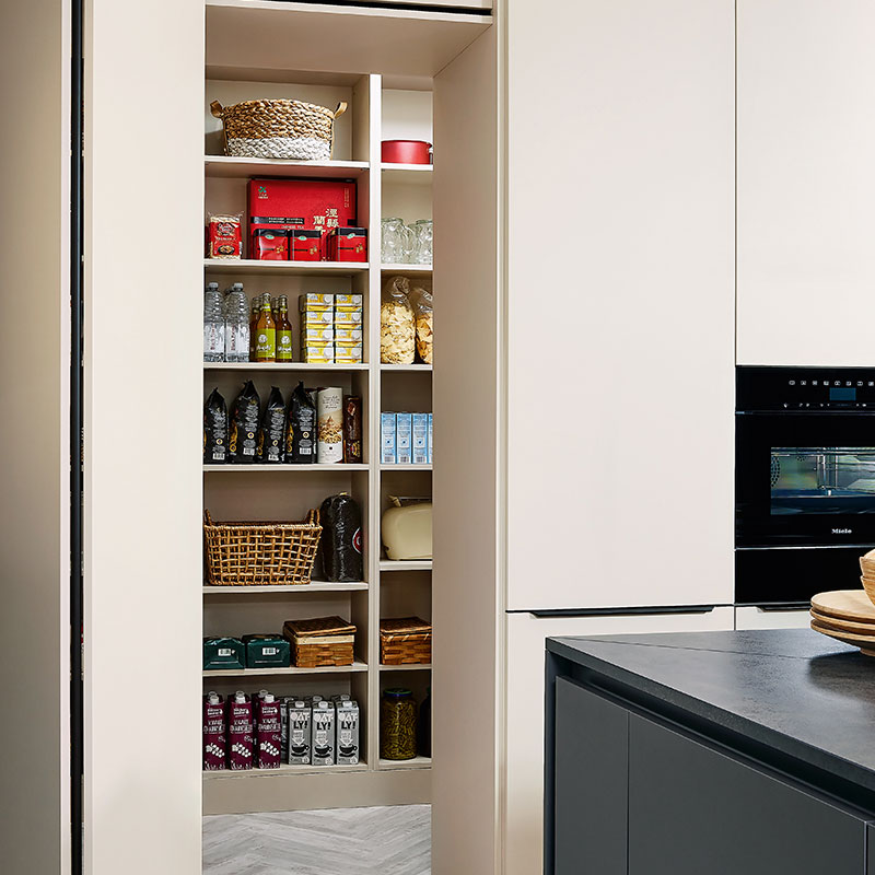 Beige keuken met open voorraadkast vol producten en ingebouwde oven