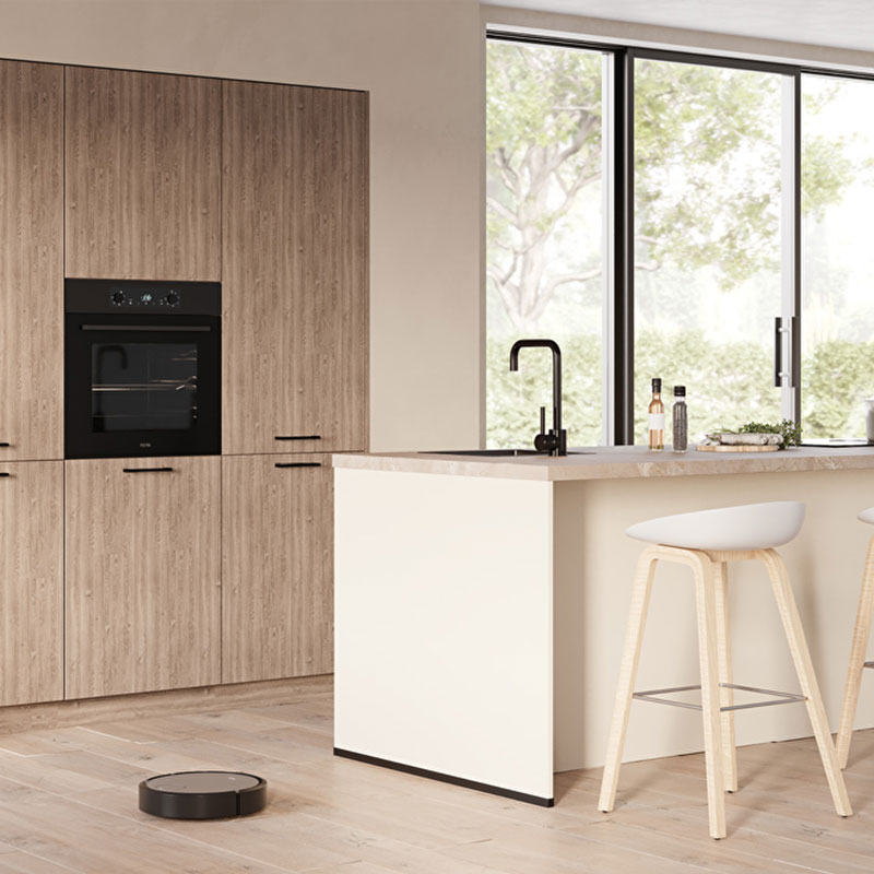 Moderne keuken met beige kookeiland, houten kastenwand en zwarte kraan bij grote ramen