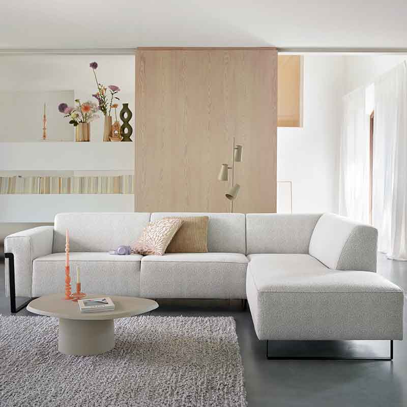 Een grijze bank met kleurrijke accessoires in een woonkamer