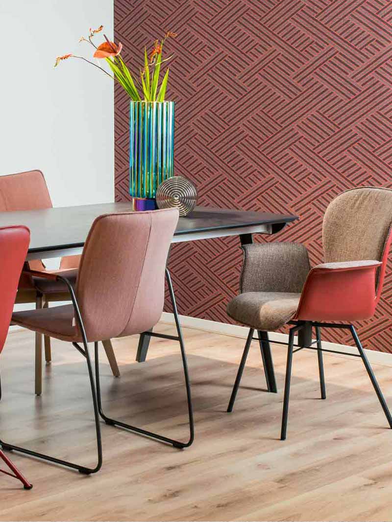 Zithoek met houten eettafel meerdere eetkamerstoelen met roze, rode en bruine kleuren