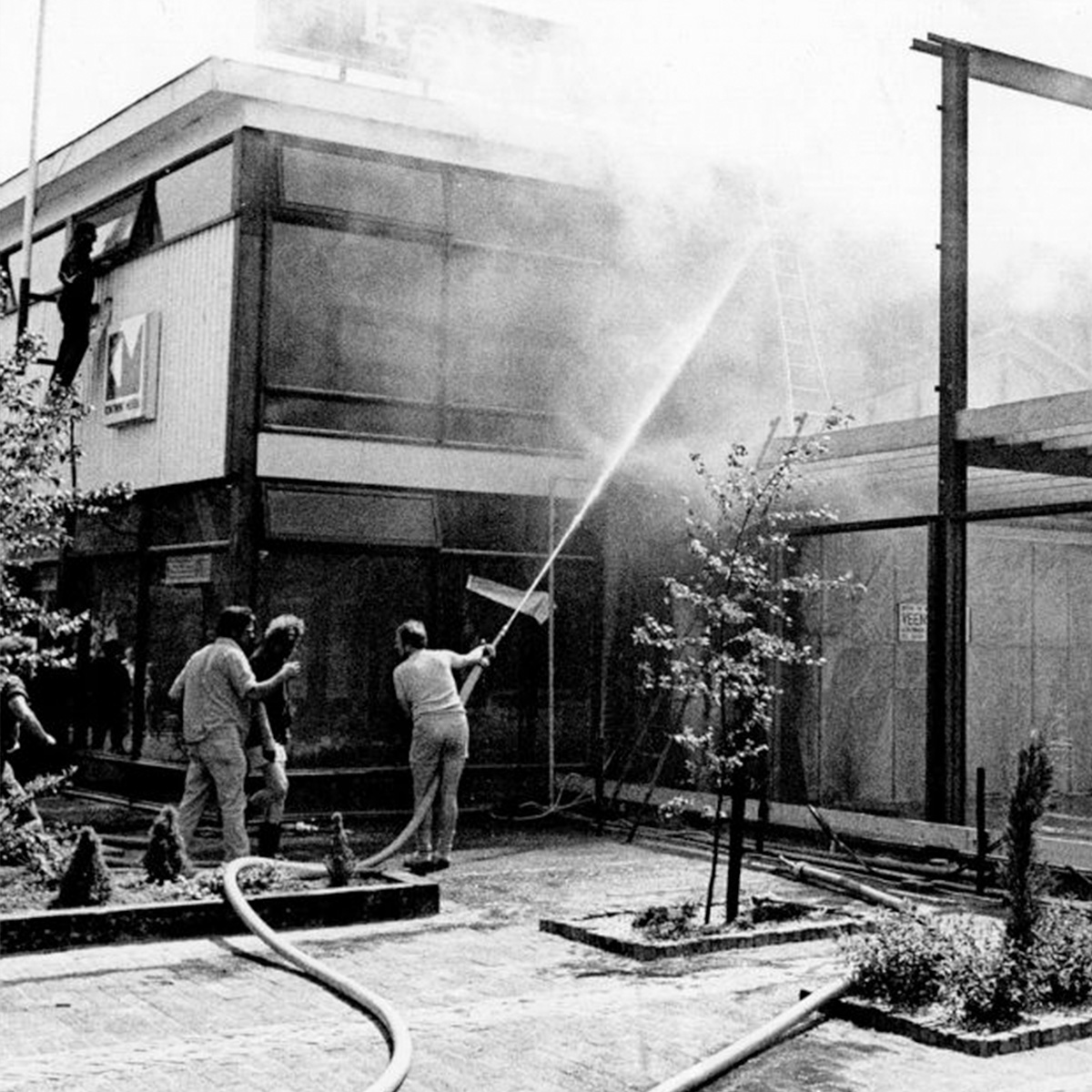 een aantal mensen die een brand staan de blussen van vroeger