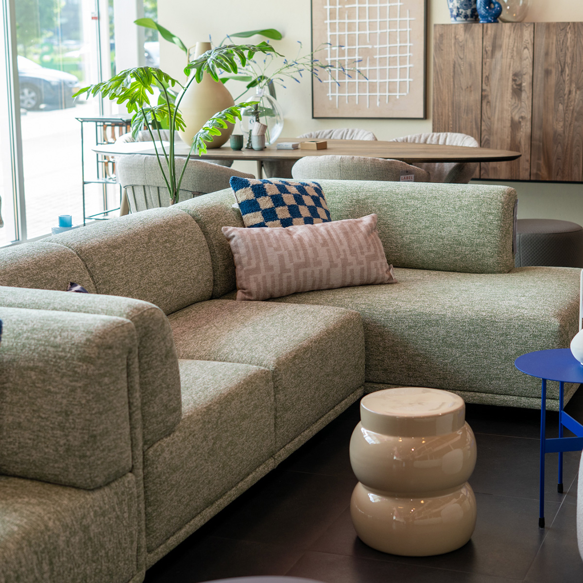 Groene design hoekbank in de showroom van Kapenga Wonen Leeuwarden met sierkussens en accessoires