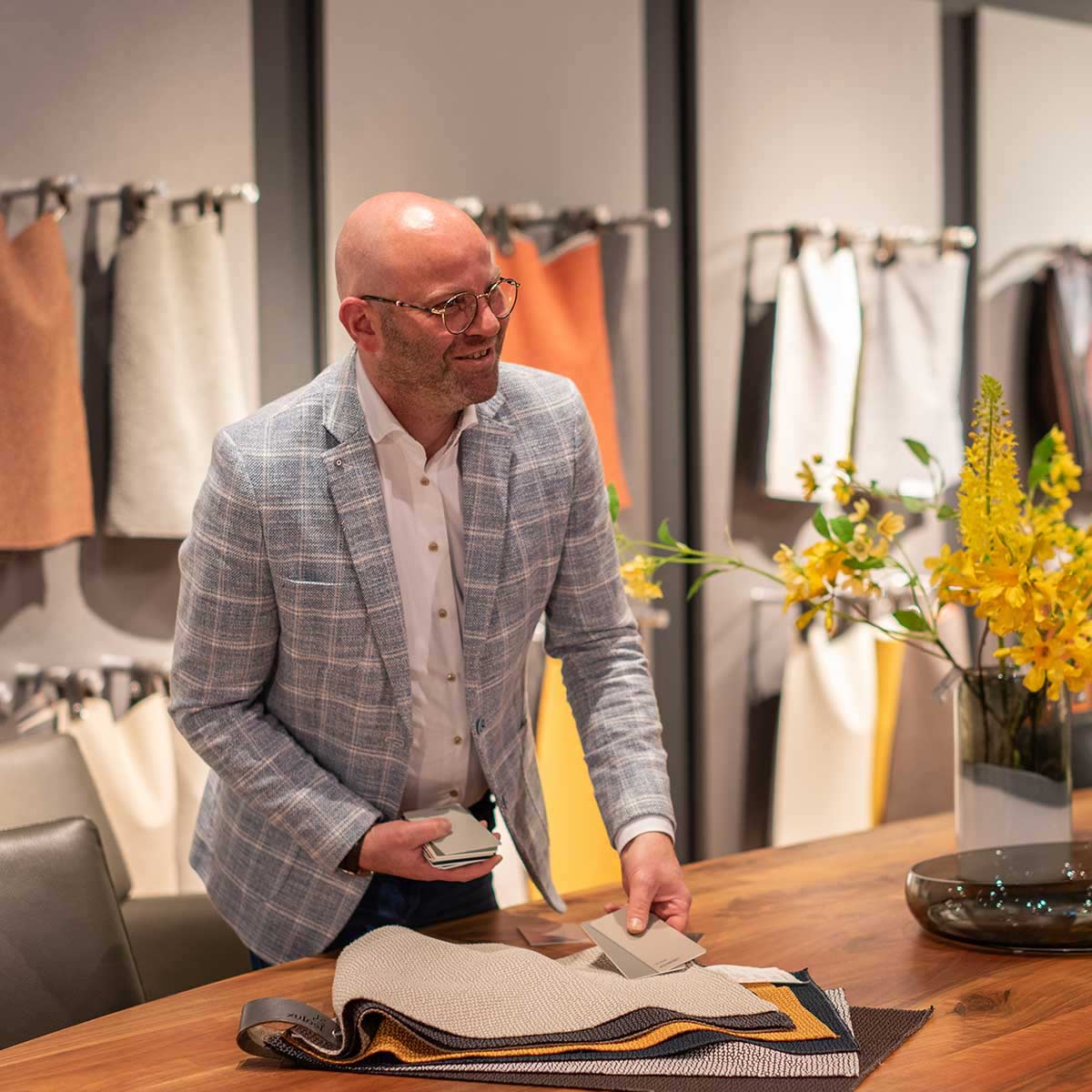 Designadviseur toont stof- en kleurstalen tijdens persoonlijk interieuradvies in een design center met designmeubelen