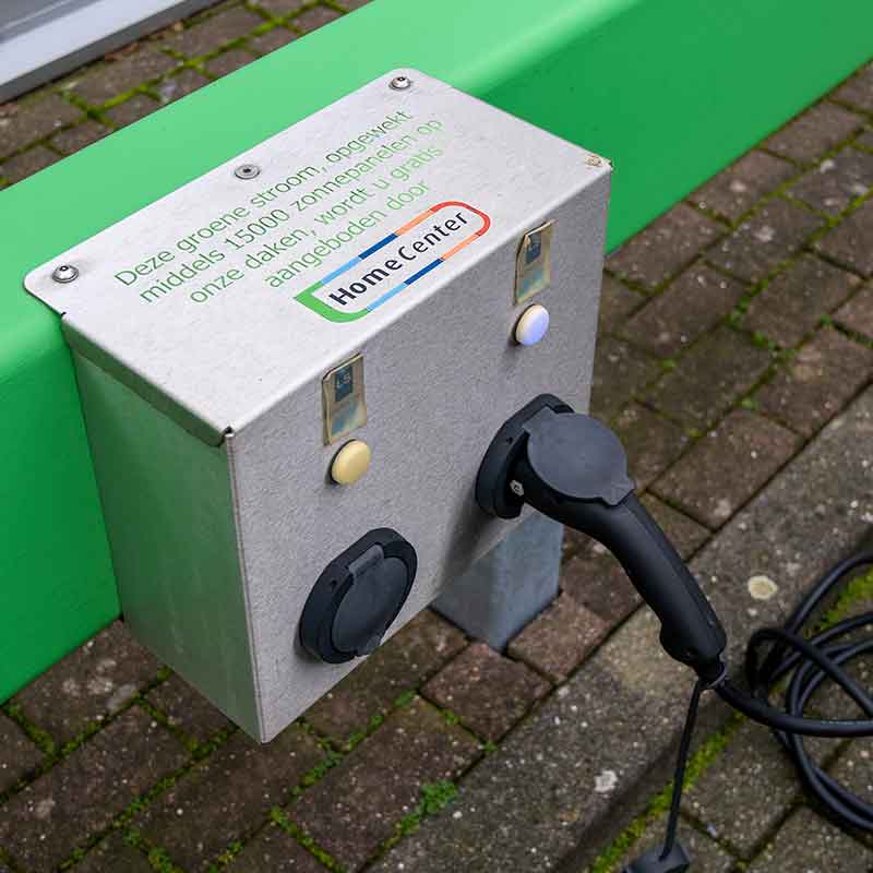 Een laadpunt voor de auto of fiets op het parkeerterrein van Home Center