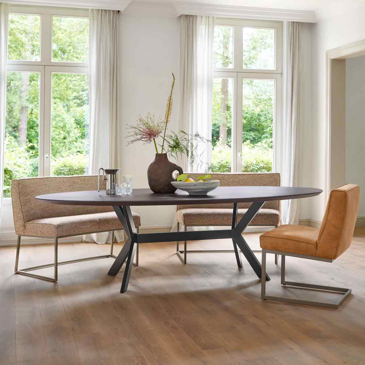 Eethoek met oranje en bruine eetkamerstoelen en een zwarte ovale eettafel