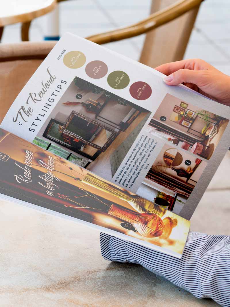 Handen bladeren door folder met woonartikelen