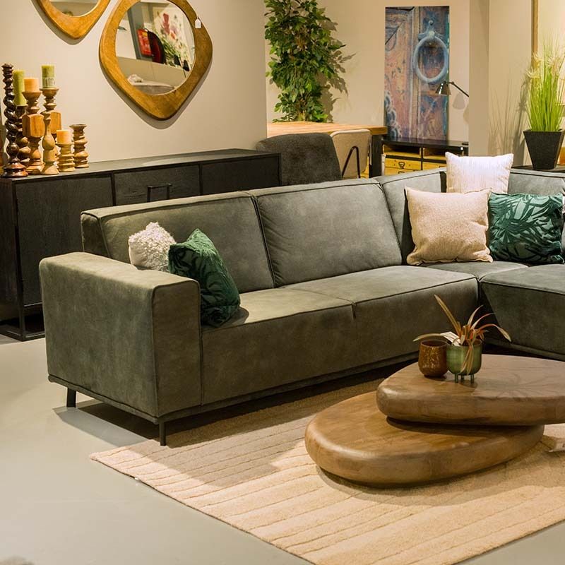 Een oudroze hippe fauteuil van Zuiver met bruine rotan rugleuning.