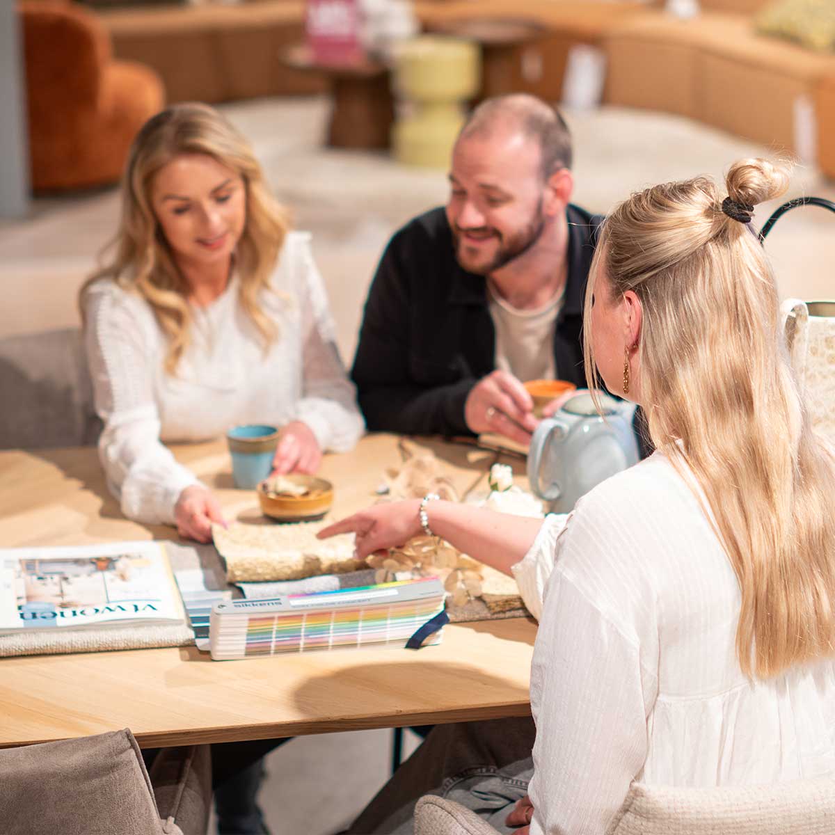 Gratis interieuradvies gesprek met interieurstylist met stofstaaltjes, kleurenwaaiers en kopje koffie