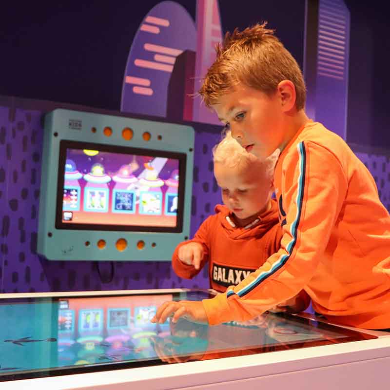 Twee jongetjes die een spel spelen op een digitaal scherm in het kinderdorp