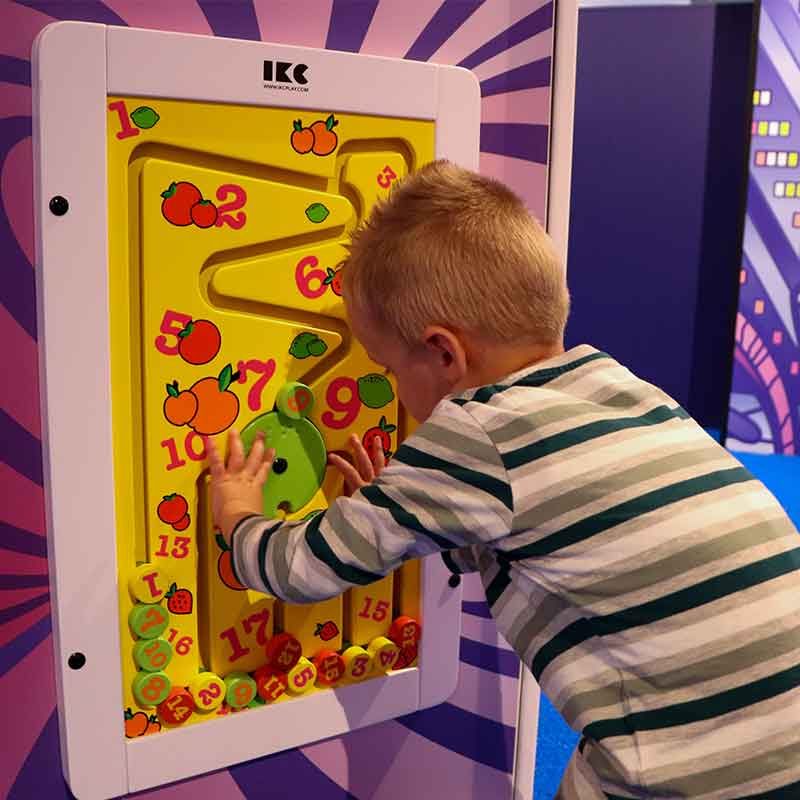 Een kind dat speelt met een puzzel aan de muur van het kinderdorp