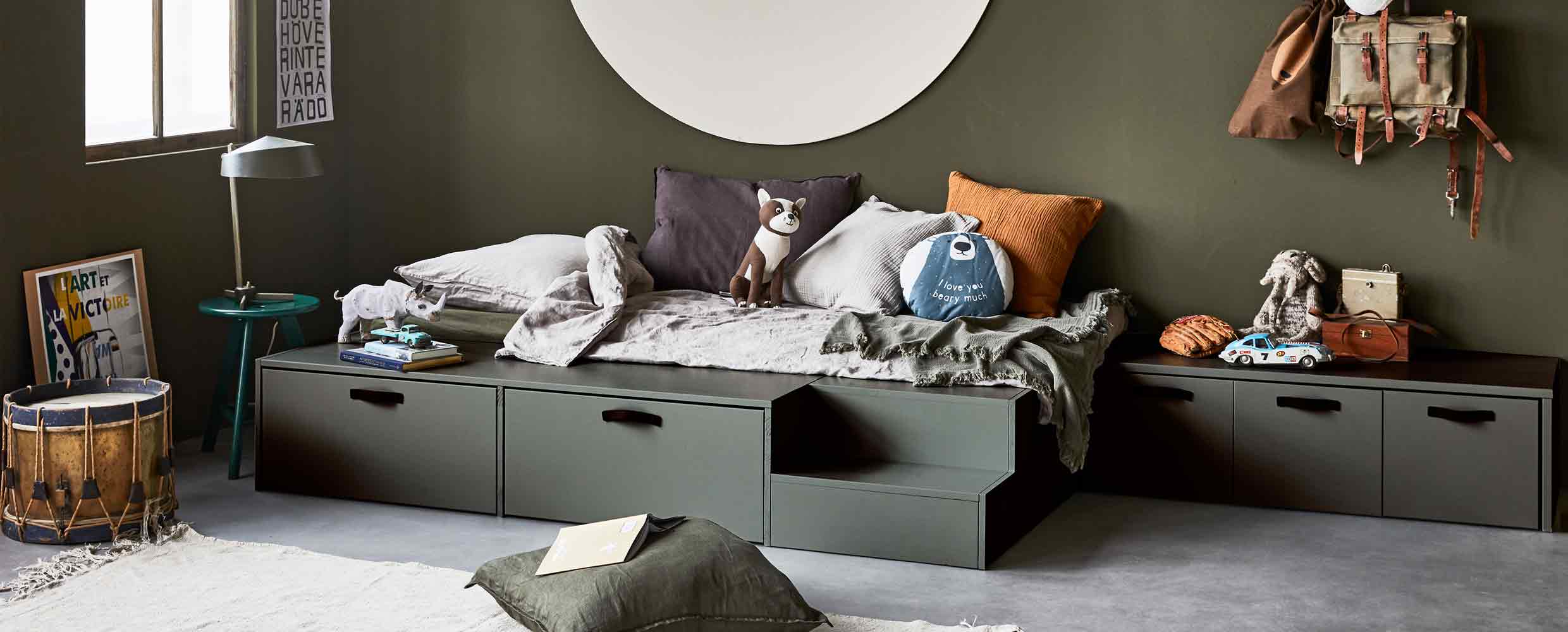 Een donkergroene kinderkamer met een donkergroen bed met lades