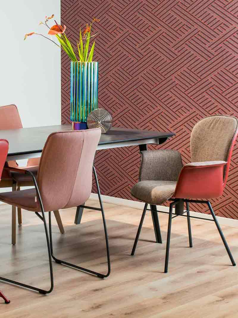 Een eethoek met roodroze gekleurde eetkamerstoelen