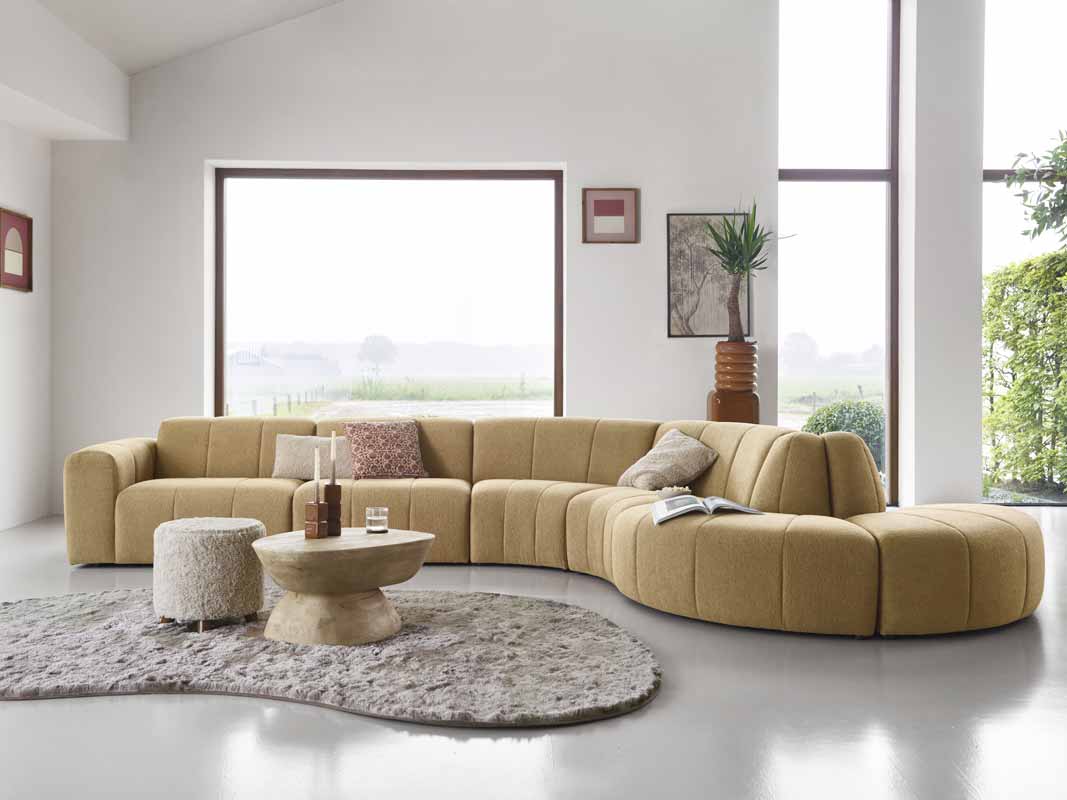 Okergele modulaire bank van INHOUSE in een woonkamer in een organische vorm