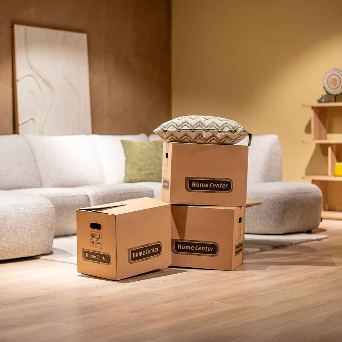 2 magazijn medewerkers laden een vrachtenwagen in, ze geven een verhuisdoos over