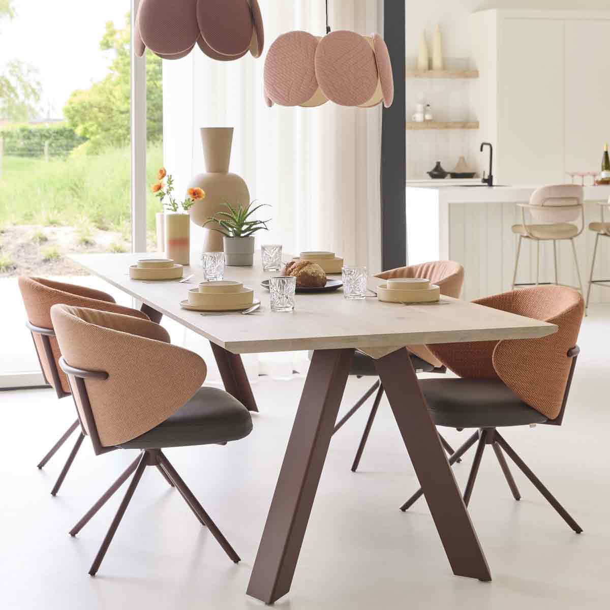 Een eethoek van Bert Plantagie met rode en roze tinten en een houten eettafel met strakke vormen