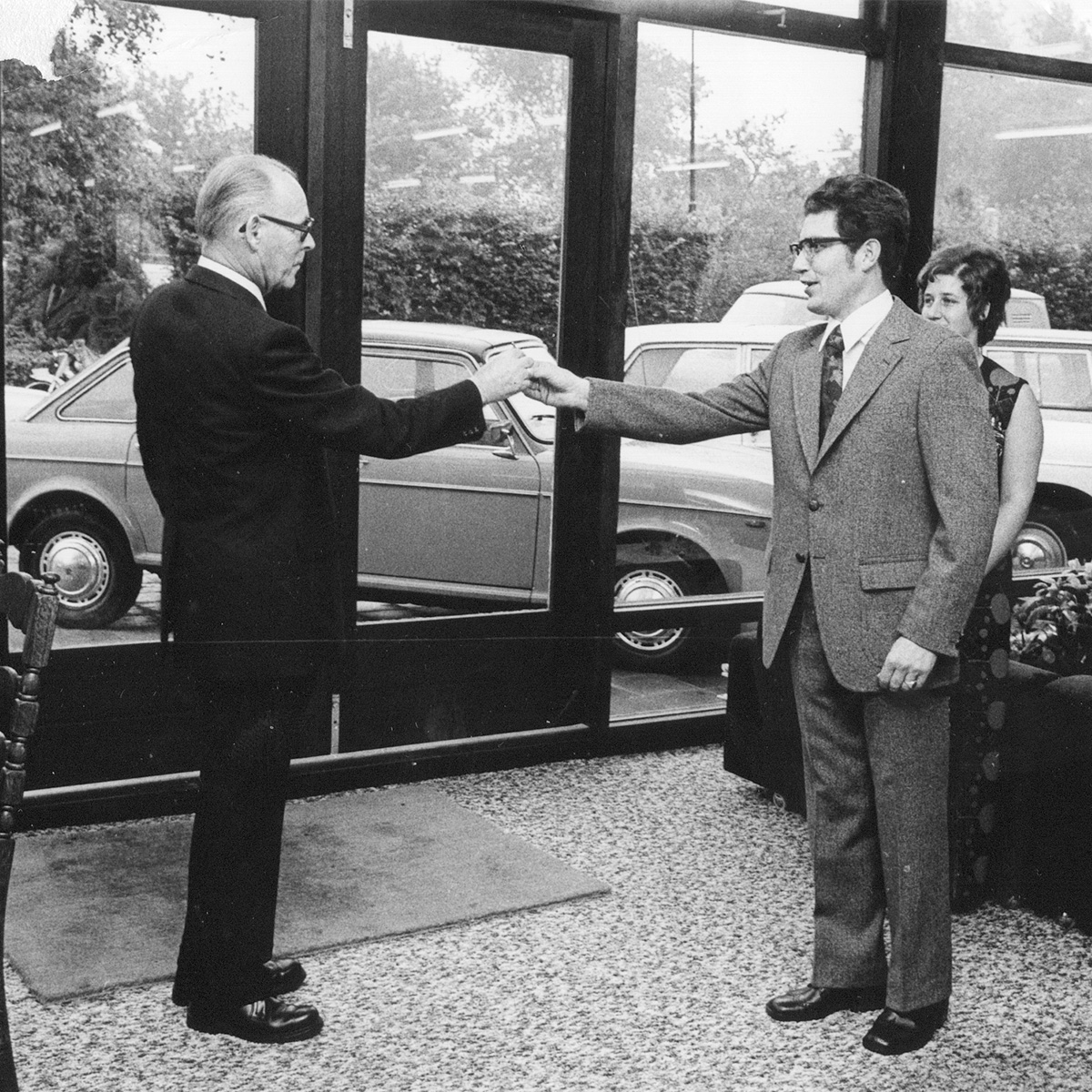 foto van vroeger van twee mensen die elkaar de hand schudden