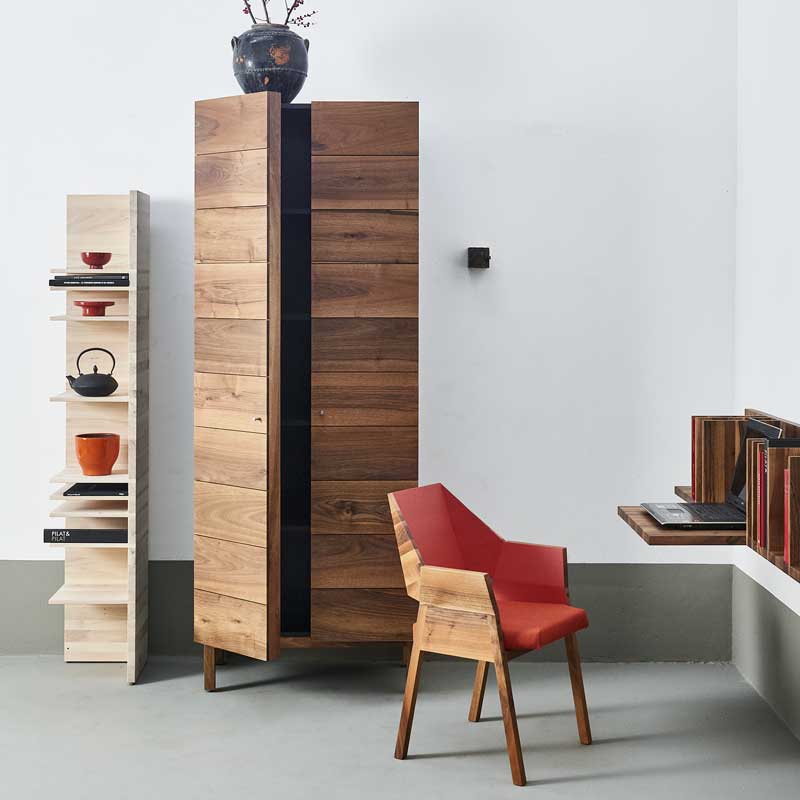 Massief houten kast en designstoel van Pilat en Pilat in minimalistisch interieur met Japans geïnspireerde details.