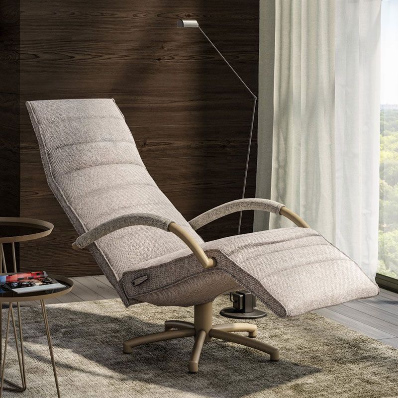 Verstelbare relaxfauteuil in lichte stof met uitklapbare voetensteun bij groot raam en tuinzicht