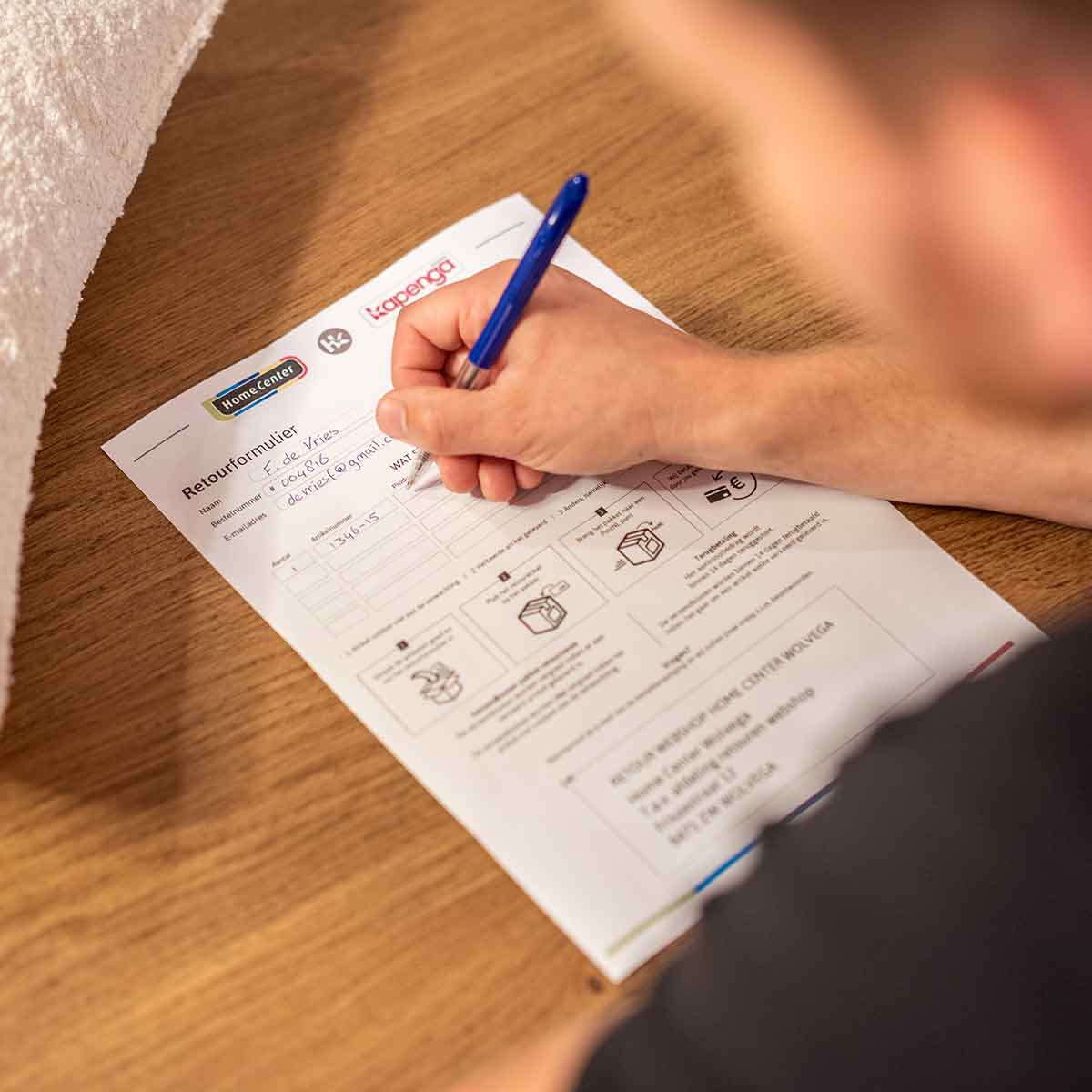 Een vrouw houdt een doos voor haar gezicht met een getekende verdrietige smiley erop