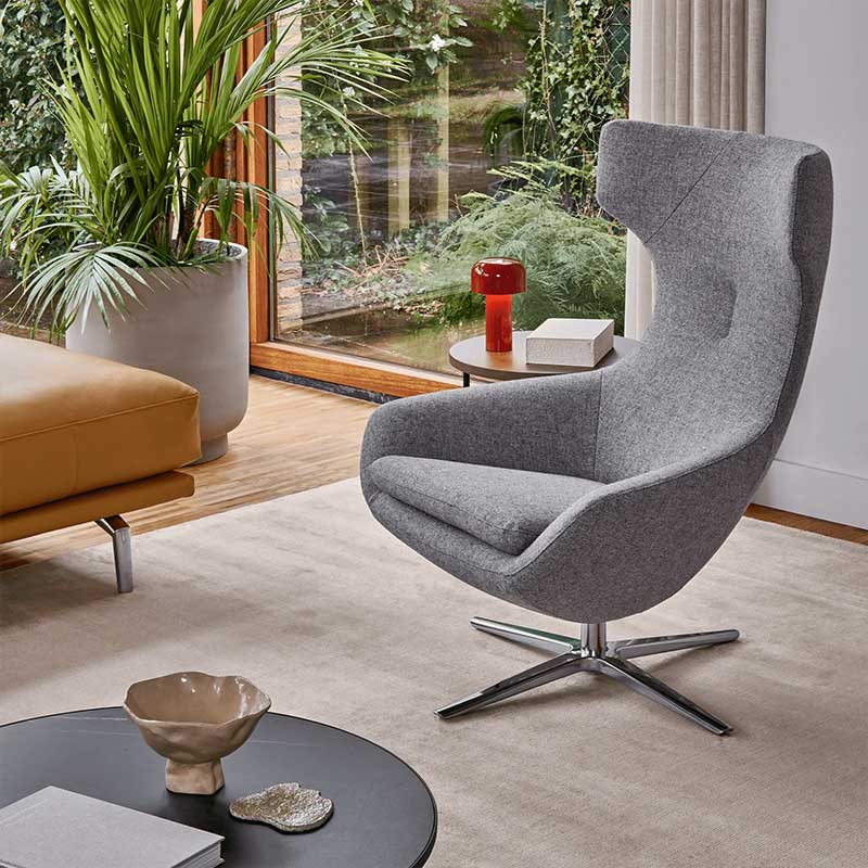 Moderne Leolux fauteuil in stijlvolle woonkamer met grote planten en designaccenten bij raam