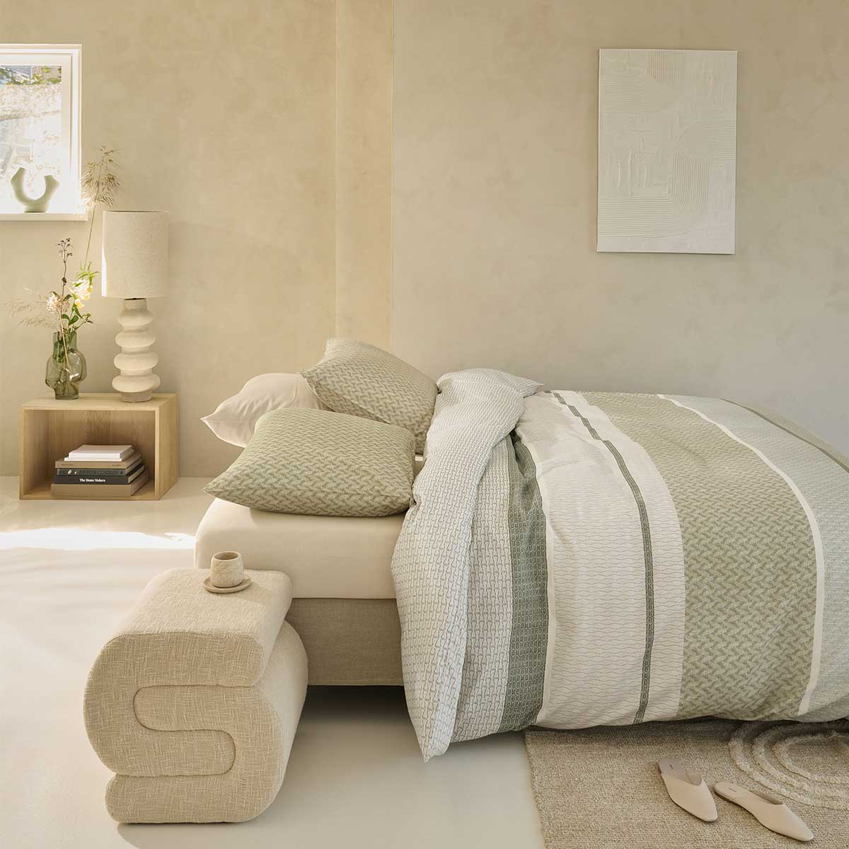 Rustige Japandi slaapkamer met zachte groentinten, minimalistisch bed, houten nachtkast en stoffen bankje