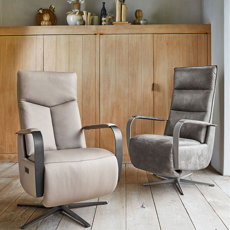Twee relaxfauteuils in leer en stof, met armleuningen en metalen draaivoet voor comfort