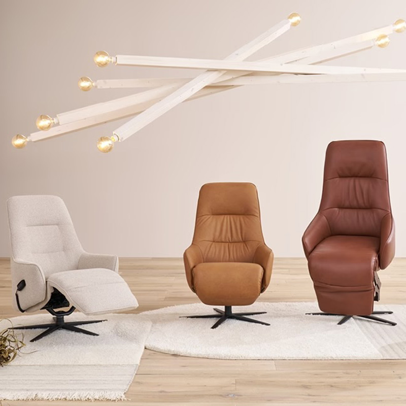 Drie relaxfauteuils in verschillende kleuren en formaten onder moderne design hanglamp