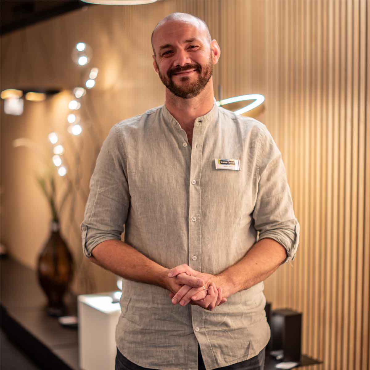 Man met lichte blouse met lampen op de achtergrond