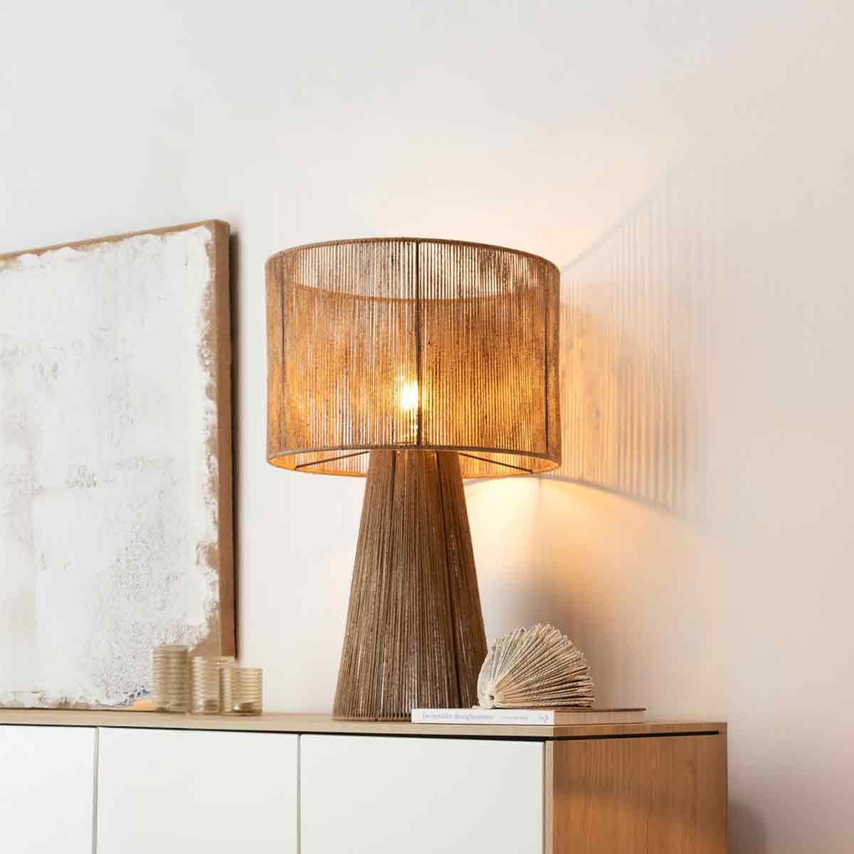 Lamp op een kast met rieten structuur en een witte achtergrond