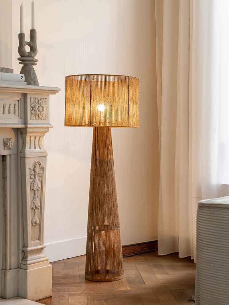Een hoge vloerlamp met een lampenkap in een bruine kleur
