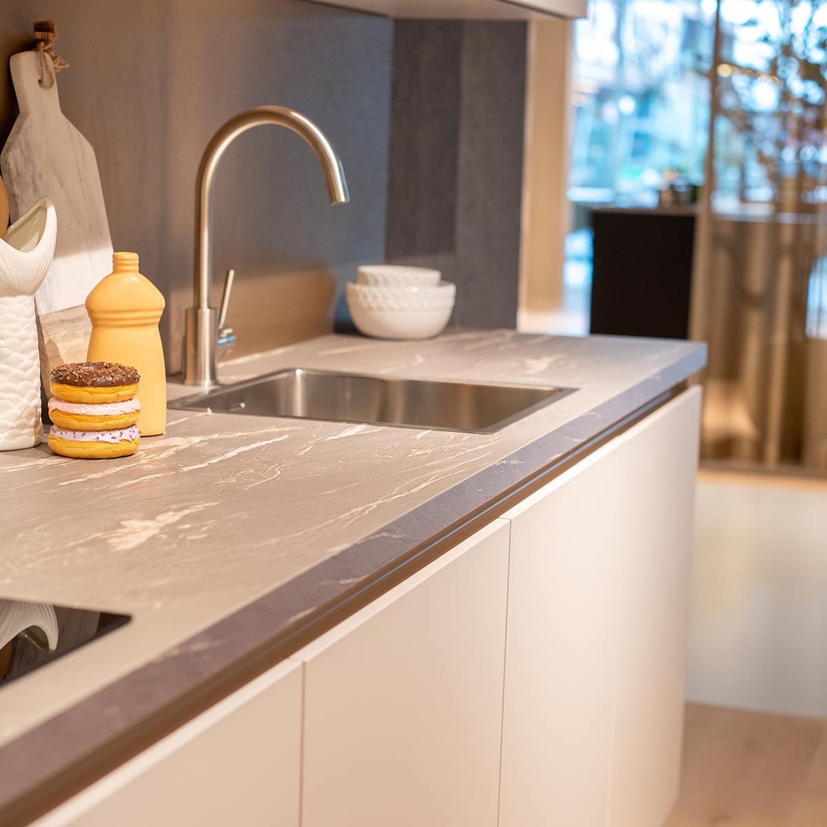 Moderne keuken met grijs marmeren werkblad, rvs kraan en witte kasten