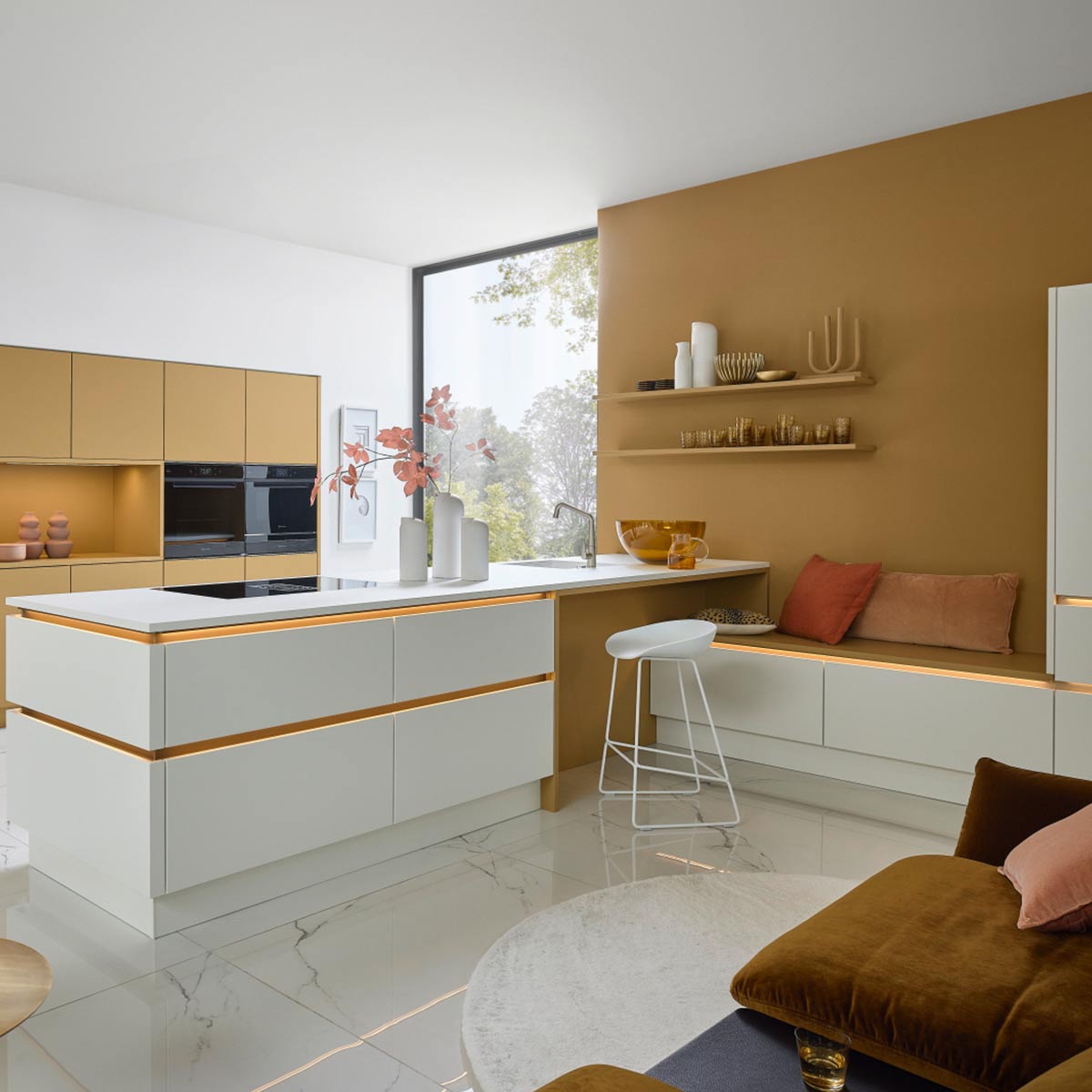 Moderne witte keuken met gele accenten, kookeiland en zithoek tegen mosterdkleurige muur