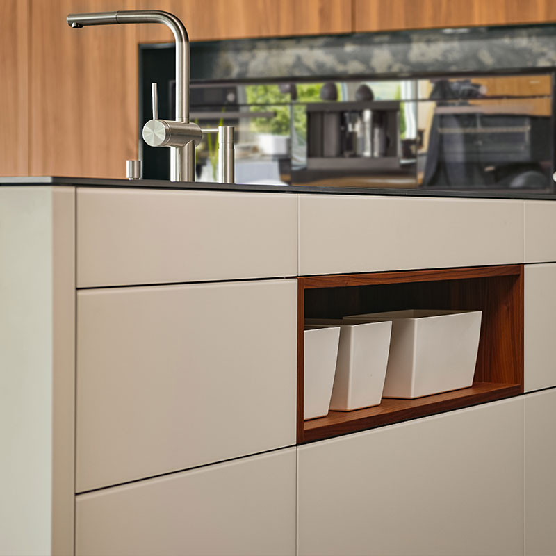 Moderne keuken met wit kookeiland, houten nis en rvs kraan op donker werkblad