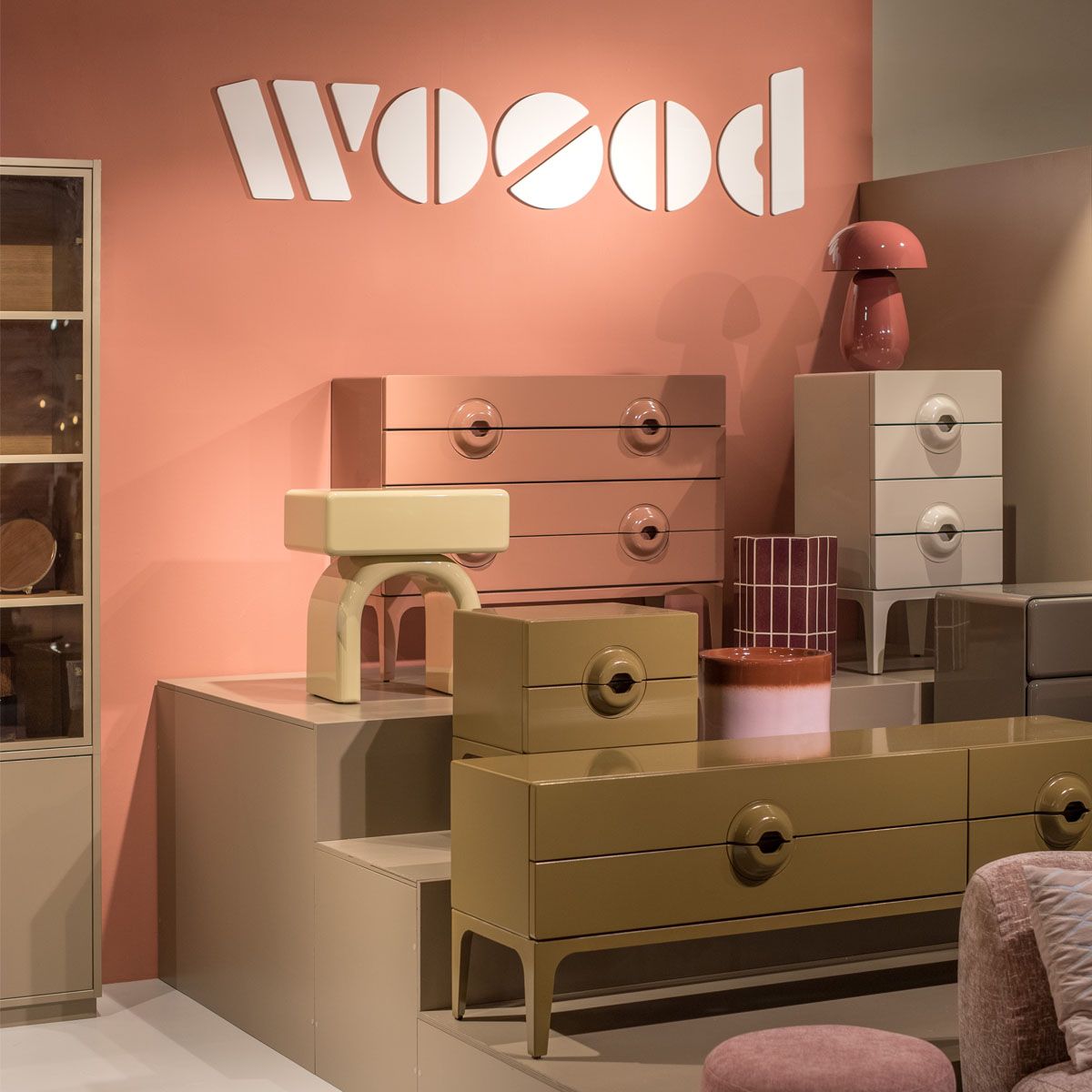 WOOOD showroom met roze wand, ladekasten in roze, beige en wit, tafellampen en woonaccessoires